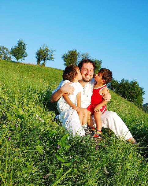 Young father in white with children on beautiful meadow - Fotoğraf, Görsel