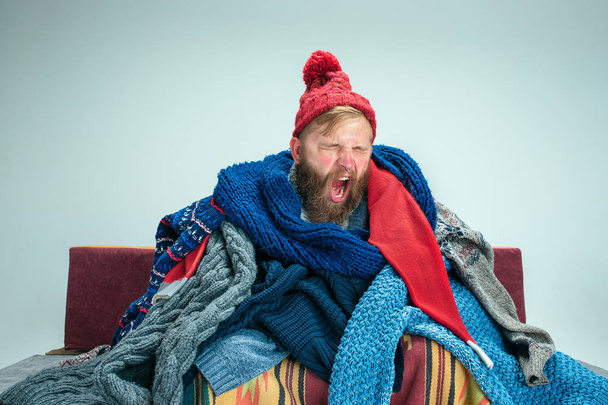 Bearded Man with Flue Sitting on Sofa at Home. Healthcare Concepts. - Photo, Image