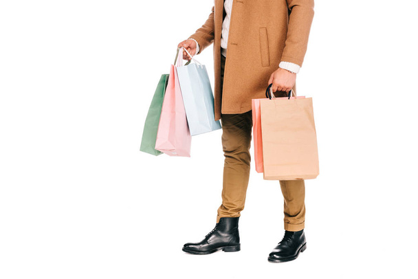 low section of man holding shopping bags isolated on white - Foto, afbeelding