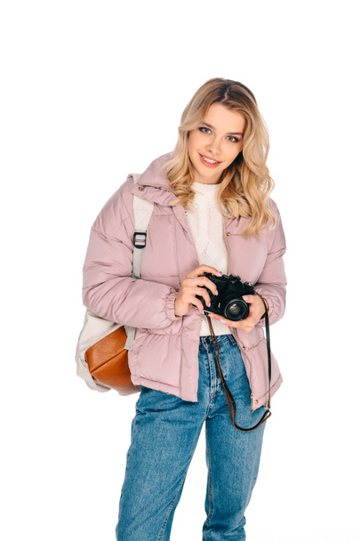 beautiful smiling girl with backpack holding camera isolated on white  - Φωτογραφία, εικόνα
