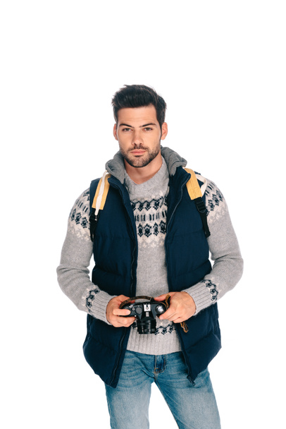 handsome young man with backpack holding camera isolated on white - Foto, Bild