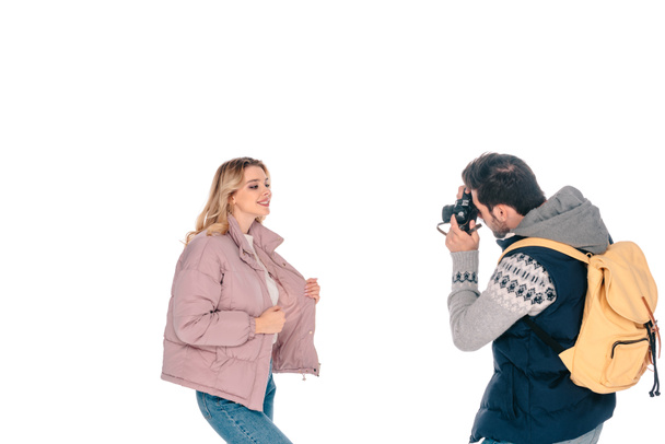 man with backpack holding camera and photographing beautiful girlfriend isolated on white - Fotografie, Obrázek