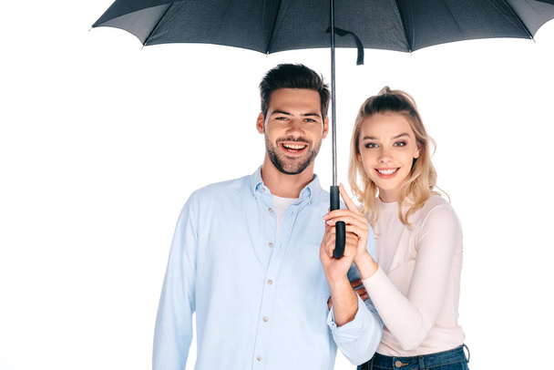 beautiful happy young couple holding umbrella and smiling at camera isolated on white - Photo, image