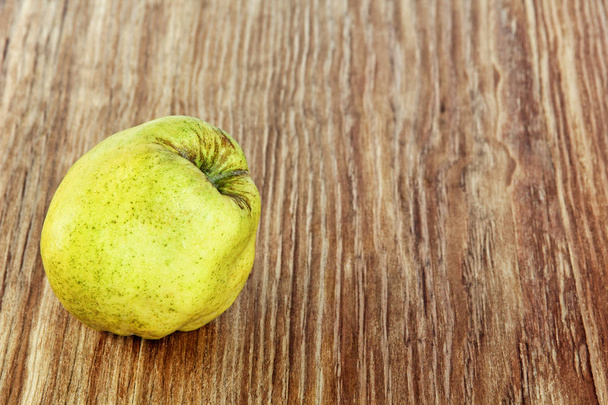 Appetizing ripe quince on grunge wooden background taken closeup. - Photo, Image