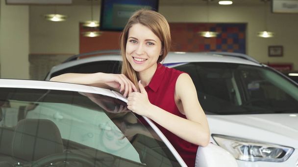 Kaunis nuori nainen poseeraa uuden auton jälleenmyyntisopimuksen
 - Valokuva, kuva