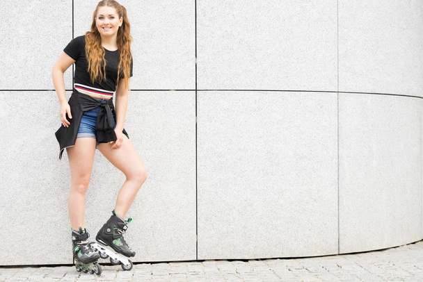 Jovem feliz usando patins na cidade. Feminino sendo esportivo se divertindo durante o verão. - Foto, Imagem