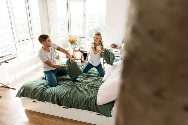 young couple in love having pillow fight on bed at home - Photo, Image