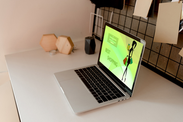 vista de cerca de la computadora portátil digital con el mejor logotipo de compras en la pantalla en la mesa en casa
 - Foto, imagen
