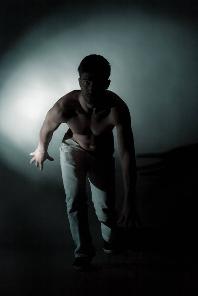 Silhouette standing man in the darkness. Studio shoot. - Фото, изображение