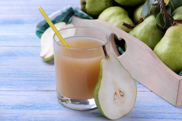 Succo di pera in un bicchiere con pere mature fresche su un tavolo di legno blu
 - Foto, immagini