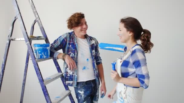 Pojęcie o przeprowadzce do nowego domu. Młoda para remontuje i farby na ściany w ich nowym domu - Materiał filmowy, wideo
