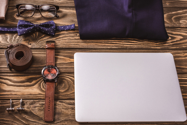 close up view of fashionable male accessories and laptop arranged on wooden surface - Fotografie, Obrázek