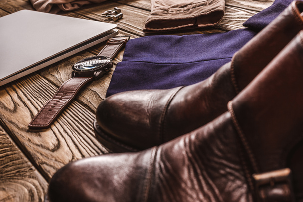 close up view of laptop, leather male shoes and clothing on wooden tabletop - Fotografie, Obrázek