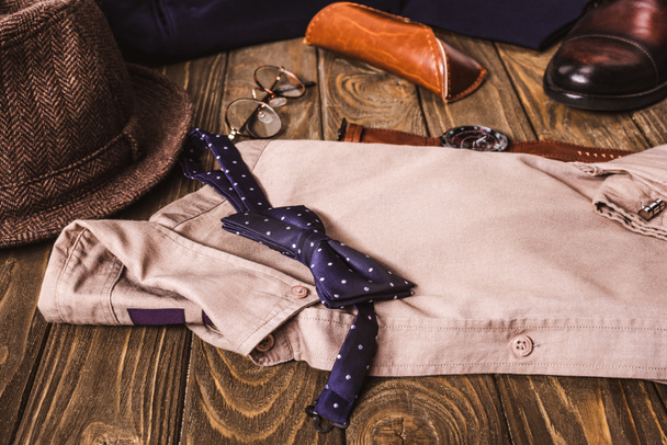close up view of arrangement of masculine shirt and accessroies on wooden tabletop - Foto, Imagem
