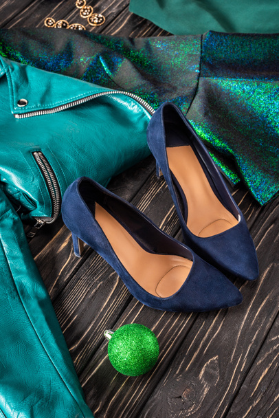 close up view of bright feminine shoes, blue jacket and earrings on wooden surface - 写真・画像