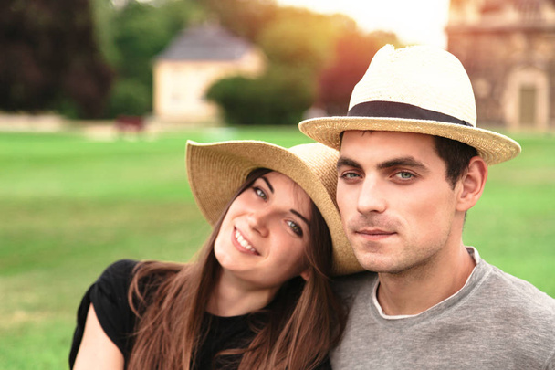 Young fit couple sit together wearing straw hats - Foto, Imagen