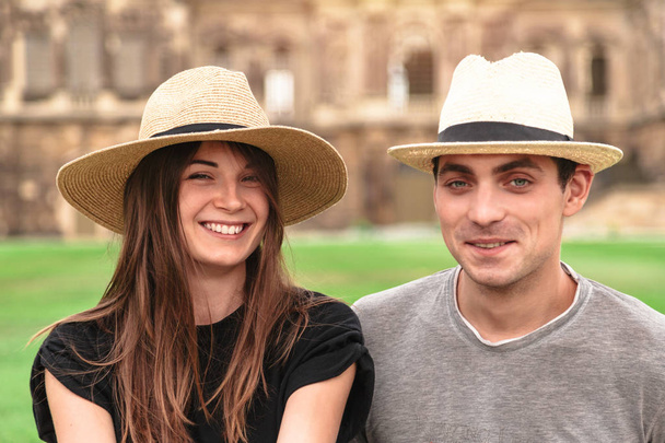 Young fit couple sit together wearing straw hats - Foto, Bild