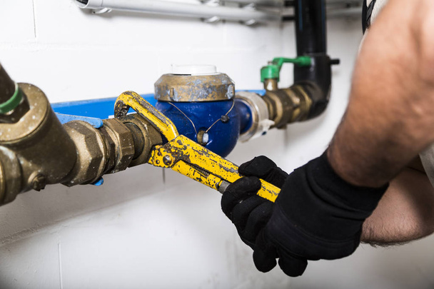 Plumber repairing metallic water pipes with manometer - Фото, изображение