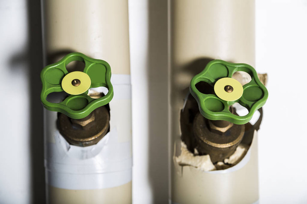 Couple of green valves on metallic pipes - Фото, изображение