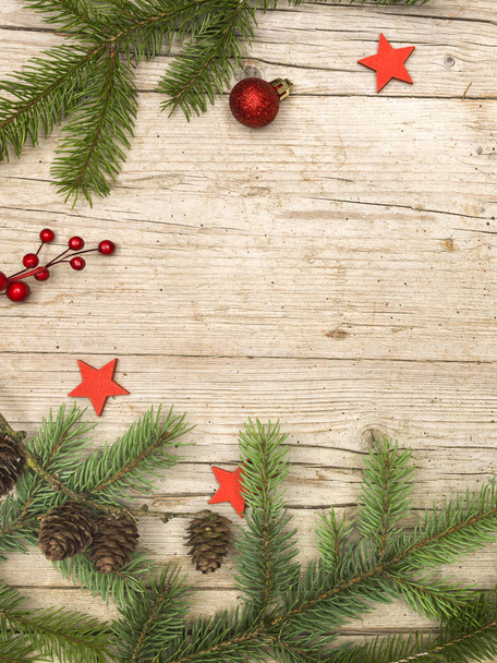 rami di abete verde con pigne e stelle rosse decorative con bauble su sfondo di legno, concetto di Natale
  - Foto, immagini