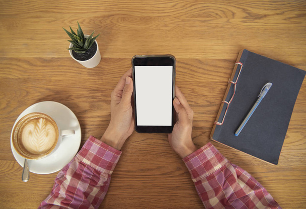 main tenant téléphone portable avec écran blanc vierge dans le café. publicité de maquette
. - Photo, image