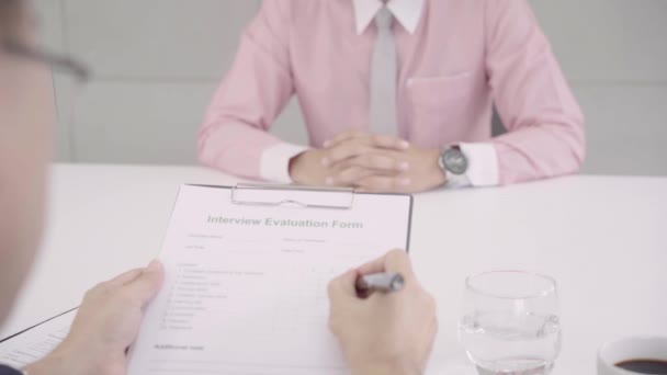 Slow motion - Attractive young Asian businessman in a job interview with corporate personnel manager who reading his CV. Asia businessman talking to male candidate at desk, interviewing job applicant. - Footage, Video