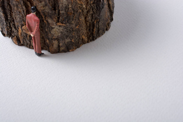 Figurine minuscule d'hommes modèle à côté d'un tronc d'arbre
 - Photo, image
