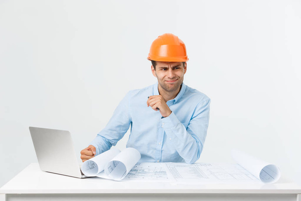 Serious man businessman or engineer sitting in construction site. Courageous middle aged man sit with sad,serious and depressed facial expression. - Photo, Image