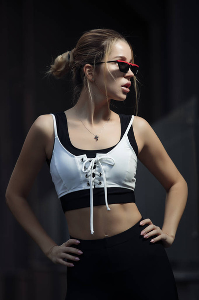 Fashionable sporty woman posing in leggings and bra with stylish eyewear - Photo, Image