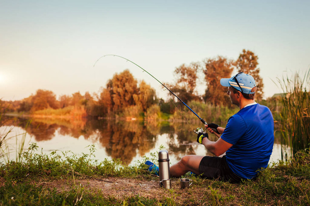 Молодой человек рыбачит на закате
 - Фото, изображение