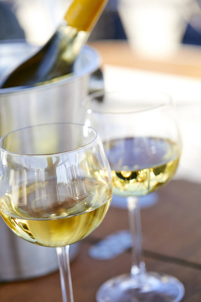 Ζευγάρι wineglasses και κουβά με λευκό κρασί μπουκάλι στο γιοτ - Φωτογραφία, εικόνα