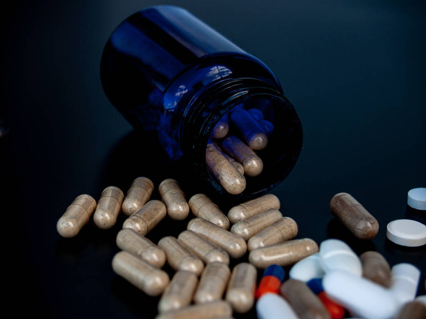 Una pentola di pillole di diverse dimensioni, forme e colori. Concetto sanitario
 - Foto, immagini