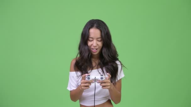 Young happy beautiful multi-ethnic woman playing games - Video, Çekim