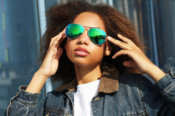 Açık havada, poz güneş gözlüğü, genç Afro-Amerikan Kız rahat kısa hacimli saç, giyinmiş. - Fotoğraf, Görsel