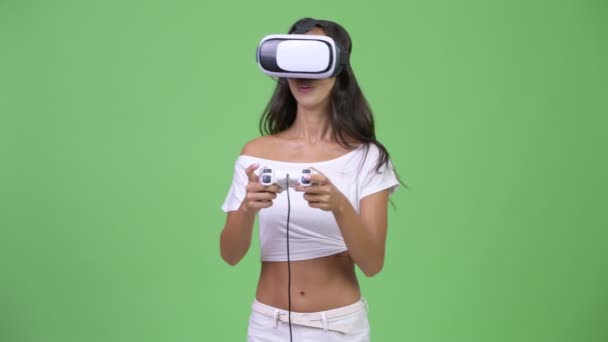 Young happy beautiful multi-ethnic woman playing games while using virtual reality headset - Video