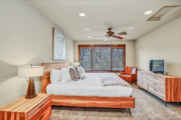 Cozy master bedroom interior features large wood bed with headboard. Northwest, USA - Zdjęcie, obraz