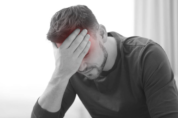 Mature man suffering from headache at home, black and white effect - Photo, Image