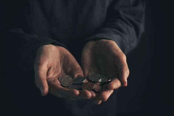 Poor woman holding coins on dark background, closeup - Photo, image