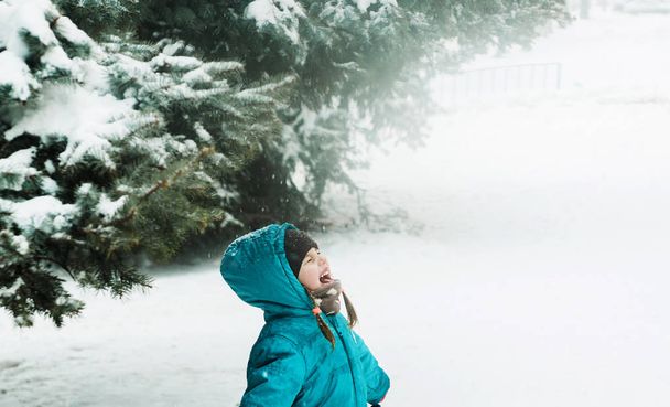 Schattig klein meisje speelt met een sneeuw. - Foto, afbeelding
