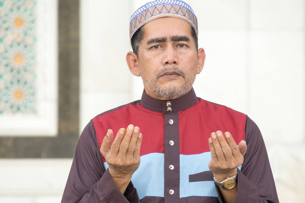 Uomo musulmano di mezza età che prega in moschea
. - Foto, immagini