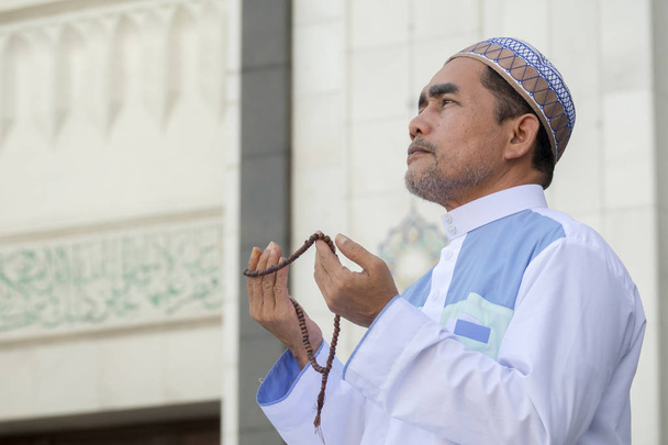 Keski-ikäinen muslimi mies rukoilee moskeija
. - Valokuva, kuva
