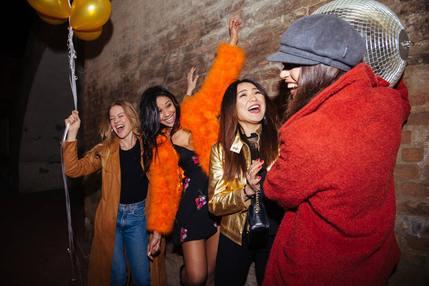 Skupina happy dívek večírek v klubu - čtyři mladé ženy s crazy oslavu narozenin v noci - Fotografie, Obrázek