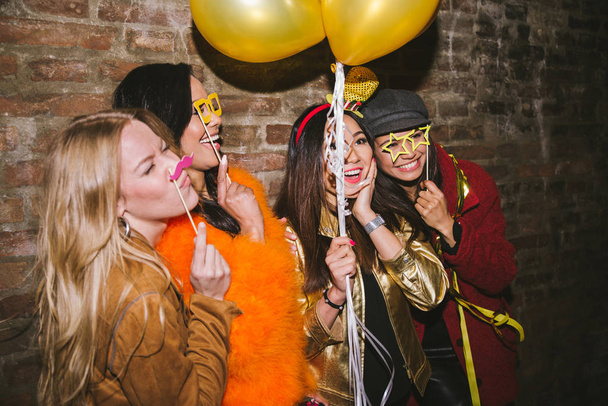 Group of happy girls having party in a club - Four young women having a crazy birthday party in the night - 写真・画像