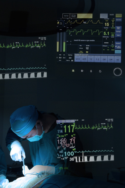 Mezcla de cirugía veterinaria en quirófano con monitorización de signos vitales del paciente con iluminación artística y filtro azul
 - Foto, imagen