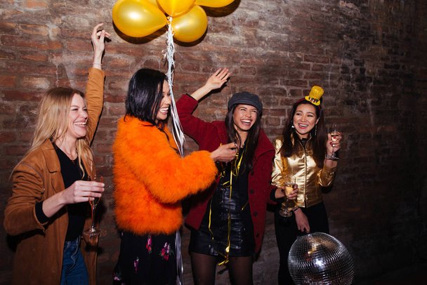 Group of happy girls having party in a club - Four young women having a crazy birthday party in the night - Foto, Imagen
