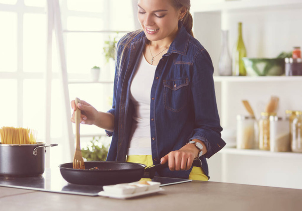 Young woman in the kitchen preparing a food - Foto, imagen