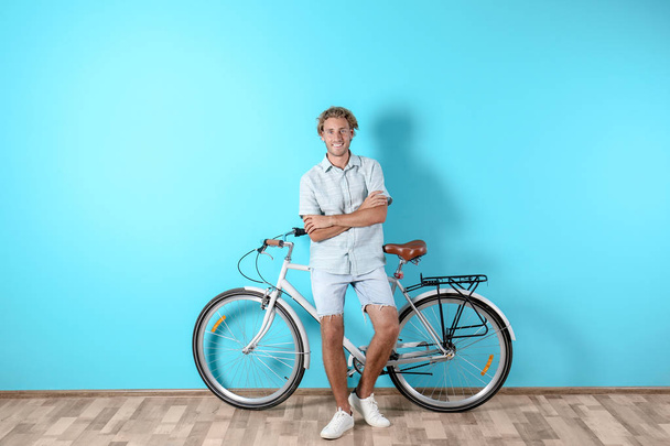 Handsome man with bicycle against brick wall - 写真・画像