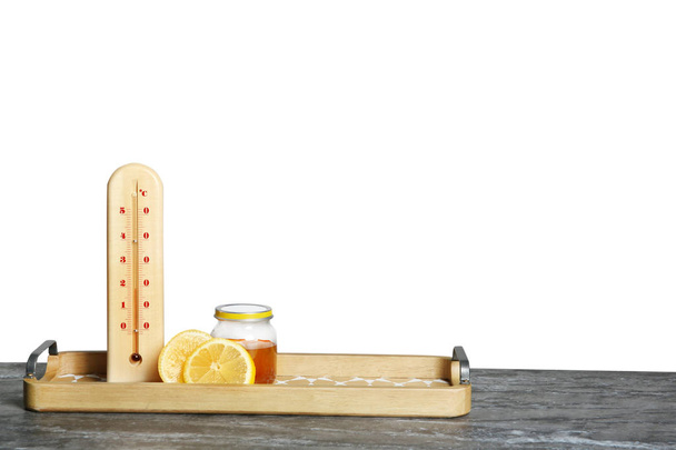 Thermometer, lemon and honey on table against gray background. Space for text - Photo, Image
