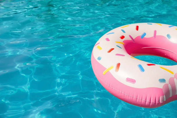 Inflatable ring floating in swimming pool on sunny day. Space for text - 写真・画像