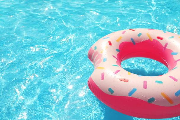 Nafukovací kruh plovoucí v bazénu na slunečný den. Prostor pro text - Fotografie, Obrázek